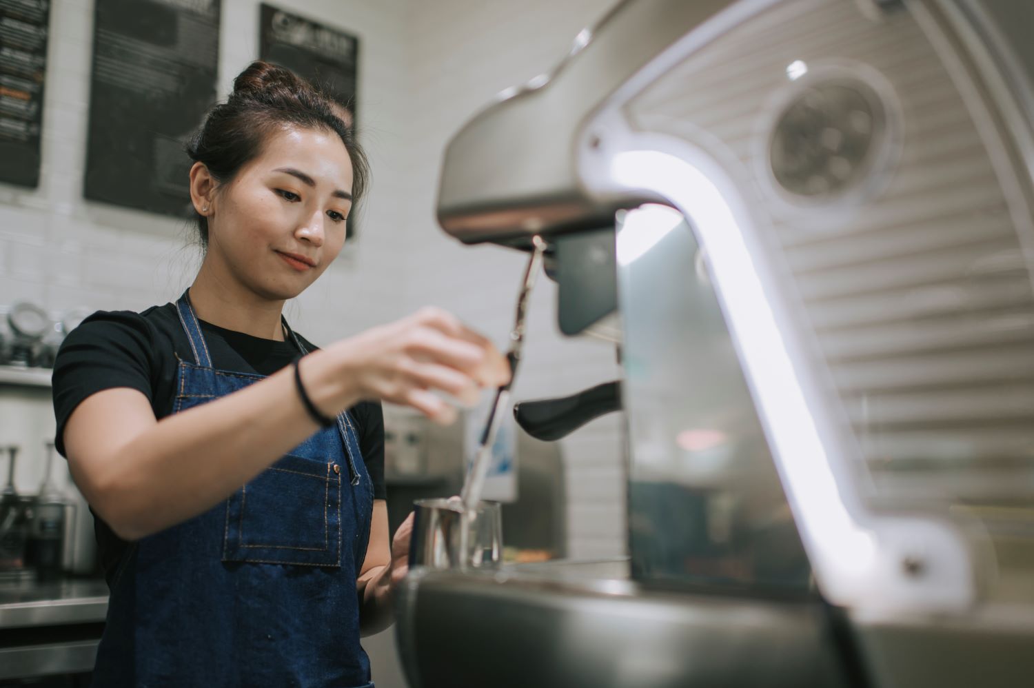 Staff member making coffee with espresso machine