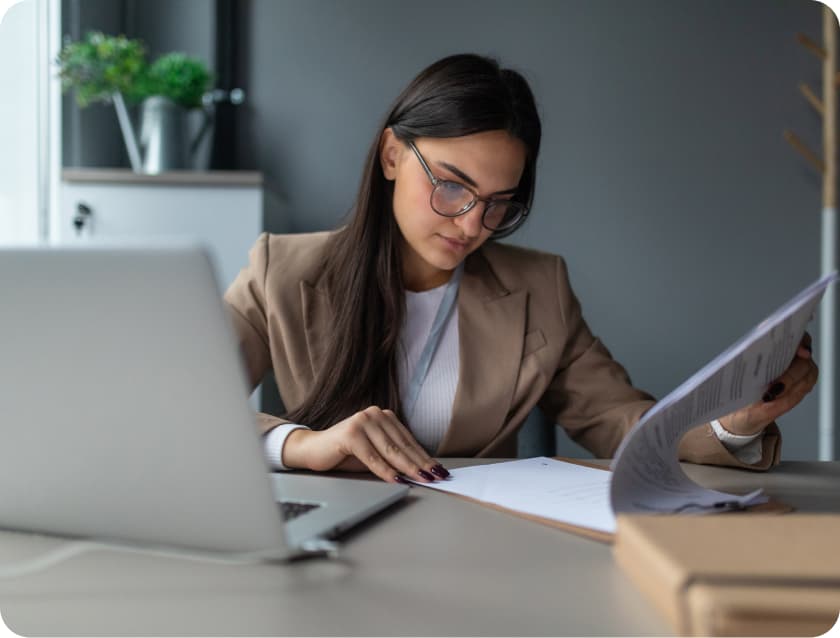 Employee Handbook - Update Woman reviewing handbook in front of laptop