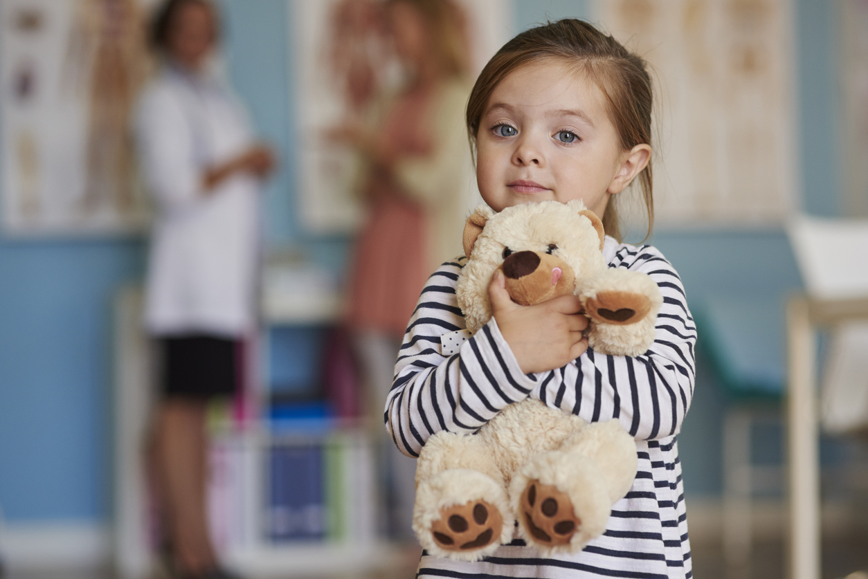 A child hugging her plush toy for comfort.