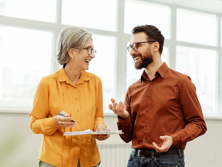 Man and women chatting standing up smiling